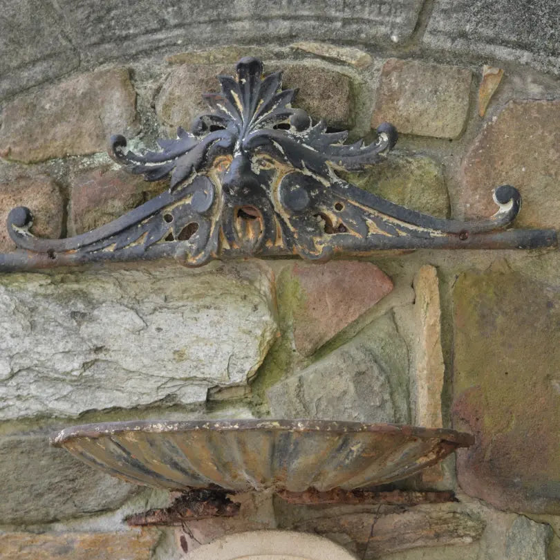 Ornate gargoyle fountain mounted on a stone wall at MacCallum More Museum & Gardens in Chase City V